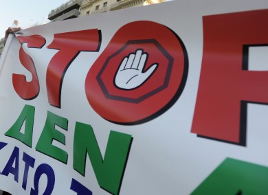 A banner held aloft during a protest in Greece calling for an end to salary cuts.
