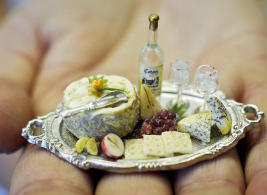 A platter of cheese and biscuits with fruit, wine, silver cheese scoop and wine glasses, made with real glass at he Karon Cunningham Miniatures shop in Bath, UK 16/11/11