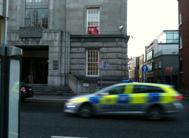A squad car passing by the building on Kildare Street just after 3.30pm today. The USI banner is visible in the window.