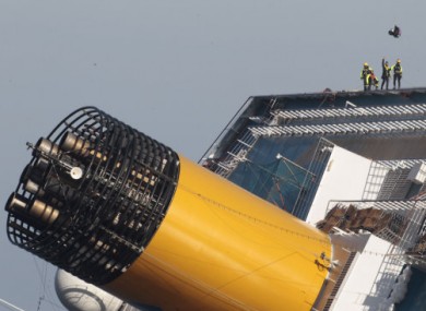 Italian firefighters are lowered onto the Costa Concordia before the search was suspended today.