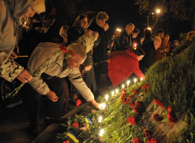 People lay flowers and light candles to honor the memory of the victims of the Chernobyl disaster in Kiev, Ukraine