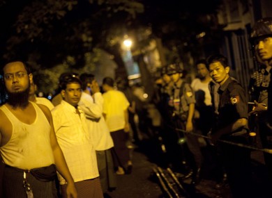 Police officers stand guard outside a mosque that a fire killed 13 children in Yangon, Myanmar.