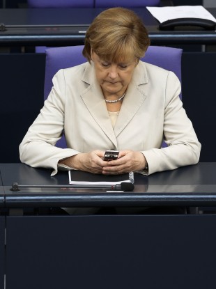 German Chancellor Angela Merkel uses her mobile phone.