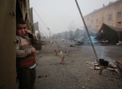 5-yrea-old Mohamed Abdo, from Hasaka, Syria, stands in front of unheated tent at the Harmanli camp