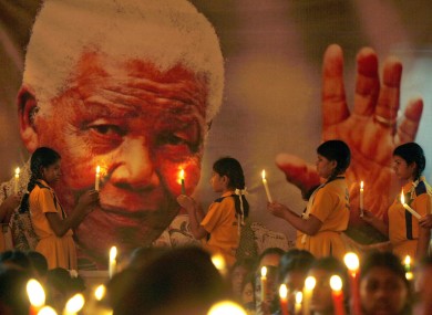 Schoolchildren hold candles near a giant portrait of former South African President Nelson Mandela in Chennai, India.