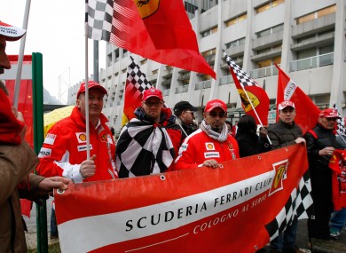 Supporters of Michael Schumacher hold Ferrari flags and a banner, to honour his 45th birthday, in front of the Grenoble hospital where the former seven-time Formula One champion is being treated.