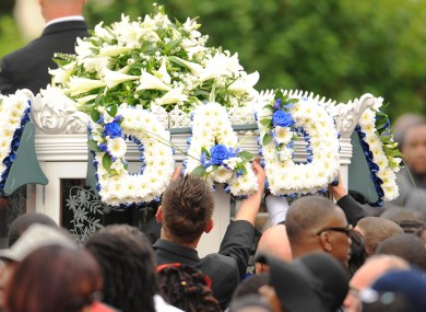 Mourners place flowers on a horse-drawn carriage following the funeral of police shooting victim Mark Duggan at the New Testament Church of God in Wood Green, north London, on 9 September 2011.