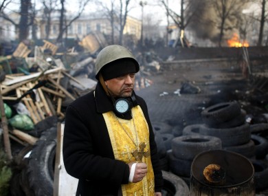 A priest stands on the barricades at Independence Square this morning.