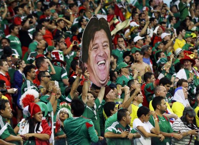 Mexico fans in full spirits with a poster of manager Miguel Herrera's head at the Arena Pernambuco in Recife last night.