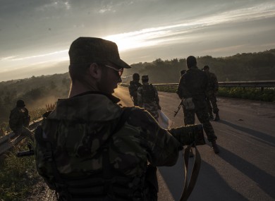 Pro-Russian fighters wait for representatives of the Ukrainian troops at a check point in the village of Karlivka near Donetsk.